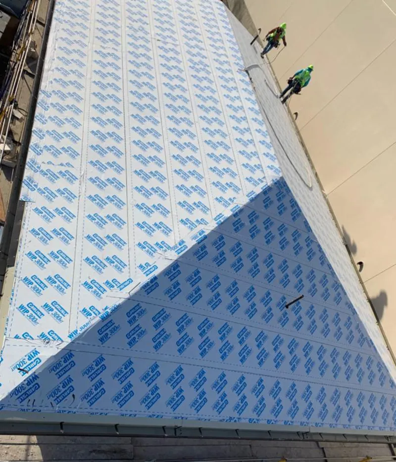 Professional roofers installing underlayment on a metal roof in Offutt AFB